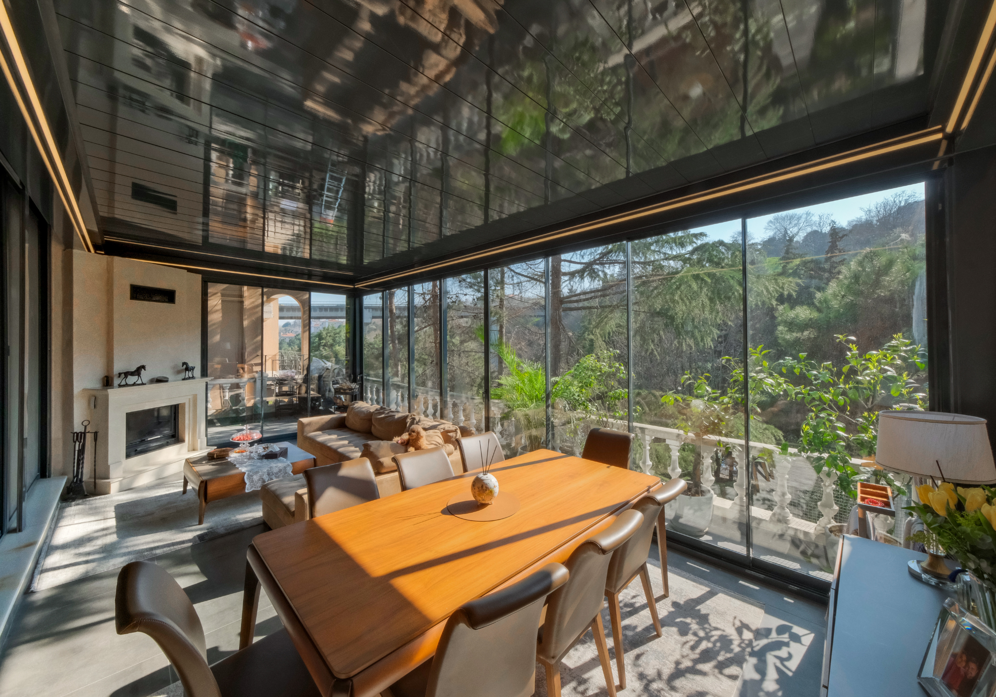 Sliding glass walls enclosing an aluminum pergola, creating a bright indoor-outdoor living space with elegant modern design by AnkaSpaces.